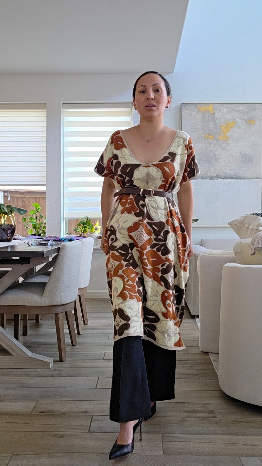Mujer con vestido floral en tonos rust, café y crema en sala moderna