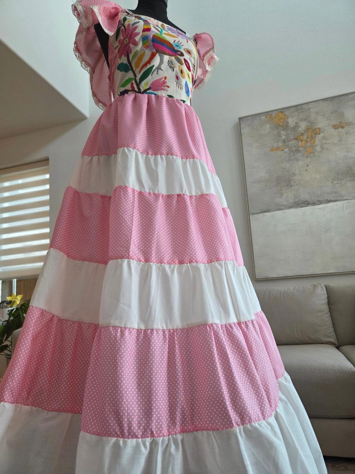 Mannequin wearing pink and white striped dress with colorful floral embroidered top and puffed sleeves