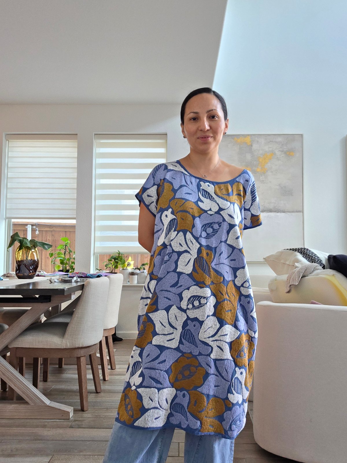 Mujer con vestido azul de flores con cuello redondo y mangas cortas en sala moderna